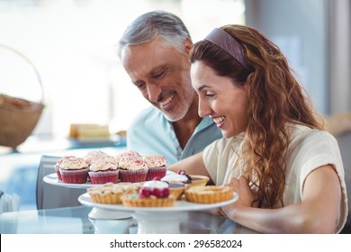 Happy couple looking at pastries in the bakery story - Powered by Shutterstock