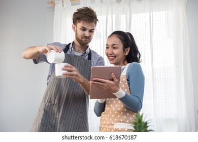 Happy Couple Looking Tablet And Cooking Breakfast On Tutorial Online In Internet Recreation In Holiday Feeling So Happiness