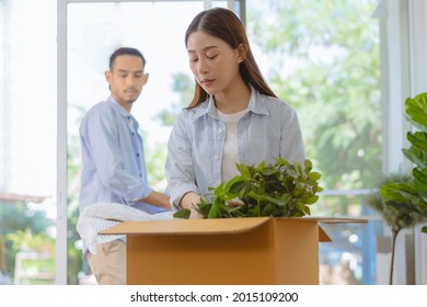 Happy Couple Love Asian Young Woman Unpack, Pack Carton Open Parcel, Put Plant Pot Decorate In Cardboard Box, Man Check List Order Moving, Preparing In New Home, Relocation. Mortgage Of House Owner.