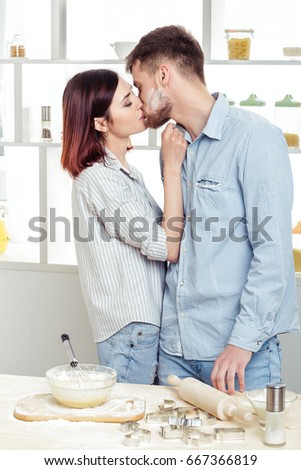 happy Couple in love cooking dough and kissing in the kitchen