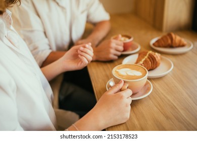 Happy couple in love drinking hot coffee with croissants, sitting in a coffee house. - Powered by Shutterstock