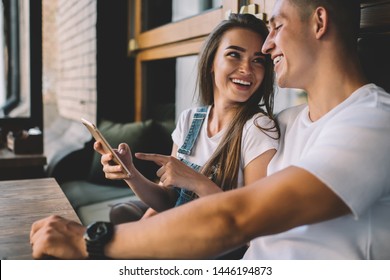 Happy couple in love enjoying live communication during online chatting with followers from share blog web page, cheerful Caucasian marriage discussing content text from publication on cellular