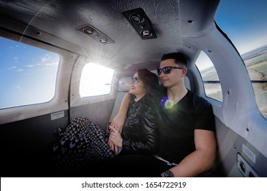 Happy couple in love is flying in the helicopter on the sunny day