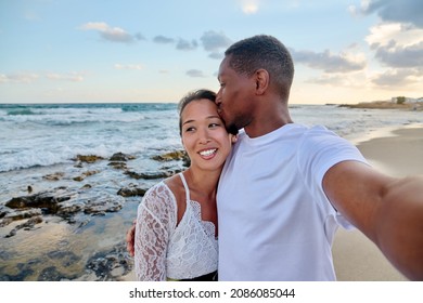 Happy couple in love kissing taking selfie together on smartphone, on beach - Shutterstock ID 2086085044