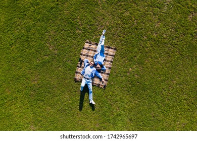 Happy Couple In Love Lying In The Park Together On Blanket From Above