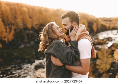 Happy couple in love newlyweds in casual clothes travel together, hike and walk in the autumn forest in nature, selective focus