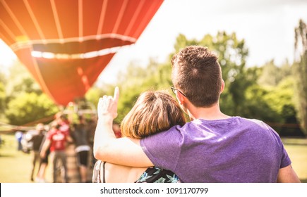 Happy Couple In Love On Honeymoon Excursion Waiting For Hot Air Balloon Ride - Summer Travel Concept With Young People Travelers Having Fun At Trip Vacation - Bright Warm Filter With Backlight