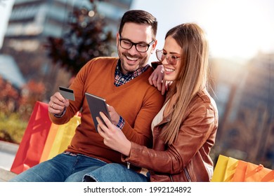 Happy couple in love spending time together and using tablet.