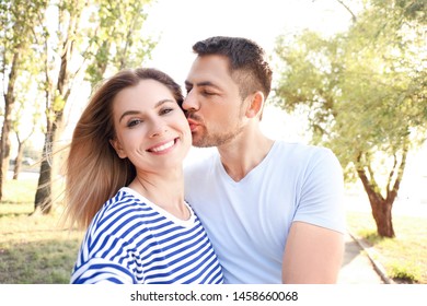 Happy couple in love taking selfie outdoors