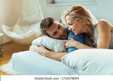 Happy Couple In Love Talking While Relaxing In Bedroom In The Morning. 