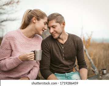 Happy Couple In Love Touched Their Foreheads, Portrait Of Man And Woman Gently Touching Foreheads To Each Other Closing Eyes, Blonde Holding Metal Cup With Hot Drinks, Tenderness In Nature Concept