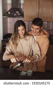 Happy Couple Making Tea Together At The Kitchen