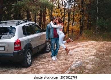 Happy couple, man and woman. Family and travel concept. Universal SUV car on a dirt road, autumn forest in the background. - Powered by Shutterstock