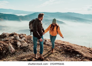 happy couple man and woman tourist at top of mountain during a hike in summer