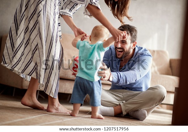 happy couple mother and father playing with a baby\
boy at home\
