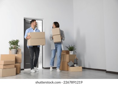 Happy couple with moving boxes entering in new apartment - Powered by Shutterstock