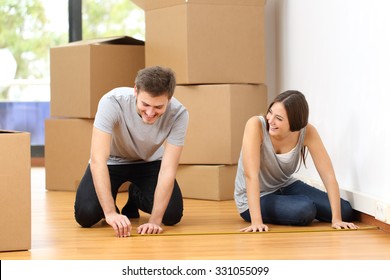 Happy couple moving house and taking measure together for the furniture - Powered by Shutterstock