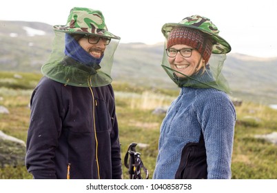 Happy couple with nets from mosquitoes in hiking trip in Sweden lapland