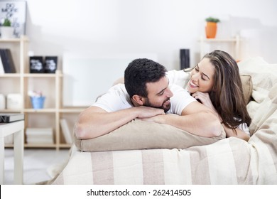 Happy Couple On Bed Sofa In Living Room