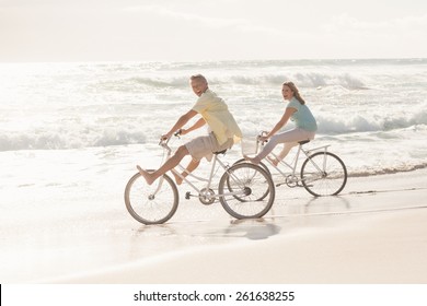 Happy Couple On A Bike Ride At The Beach