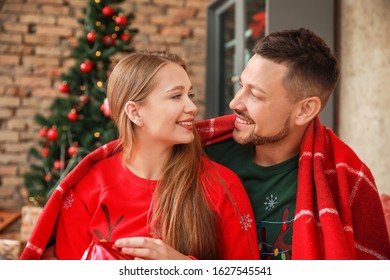 Happy couple on Christmas eve at home - Shutterstock ID 1627545541