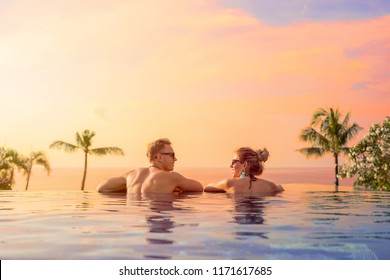Happy couple on honeymoon in luxury hotel pool