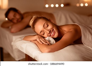 Happy Couple On Relaxing Spa Procedure Lying On Beds With Eyes Closed Resting And Enjoying Aromatherapy Indoors. Wellness And Body Relaxation, Beauty Treatment Concept. Low Light, Selective Focus