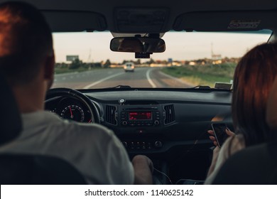 Happy Couple On Roadtrip Into The Sunset In SUV Car