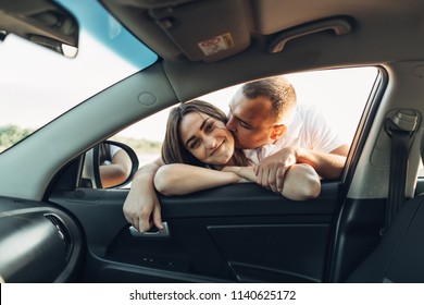 Happy Couple On Roadtrip Into The Sunset In SUV Car