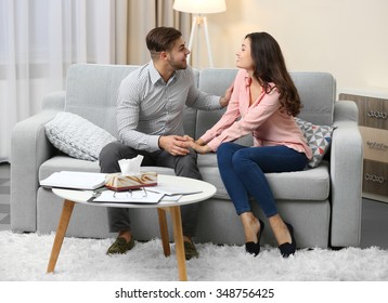 Happy couple on sofa, on home interior background - Shutterstock ID 348756425
