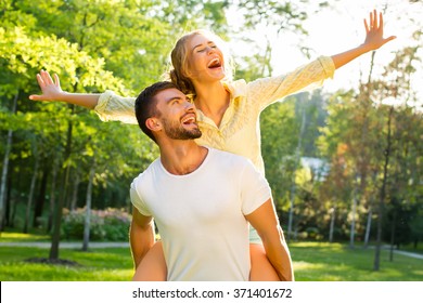 Happy couple on vacation. Lovers are laughing. Happy guy and girl. Lovers enjoy each other in the evening park. - Powered by Shutterstock