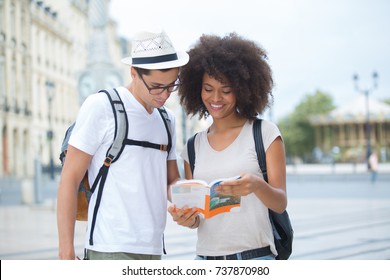 happy couple on vacation sightseeing city with map
