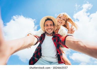 Happy Couple On Vacation. Young Man And Woman Taking Pov Selfie On The Blue Sky Background