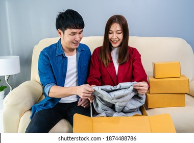 Happy Couple Open A Cardboard Parcel Box In The Living Room At Home, Purchase On Online Store