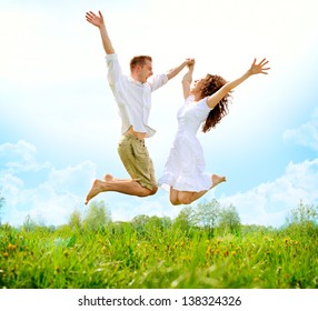 Happy Couple Outdoor. Jumping Family on Green Field. Freedom concept. Free. Jumping People. Fun