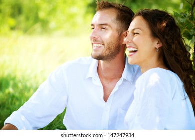 Happy Couple Outdoor. Smiling Couple Relaxing in a Park. Family over Nature Green Background. Smiling Man and Woman Having Picnic in Countryside. Relationships 