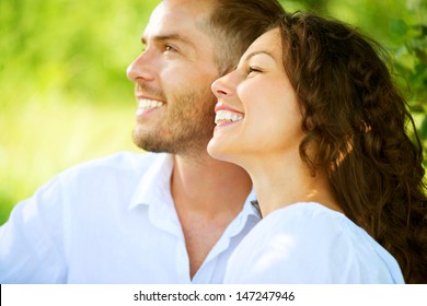 Happy Couple Outdoor. Smiling Couple Relaxing in a Park. Family over Nature Green Background. Smiling Man and Woman Having Picnic in Countryside. Relationships 