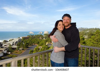 Happy Couple Overlooking Beach From Deck