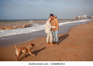 Happy Couple, Overweight Woman And Man Walking In The Beach With Dog