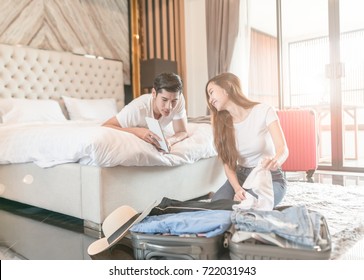 Happy Couple Packing Suitcase On Floor In Room Use Tablet For Search Travel Trip Online