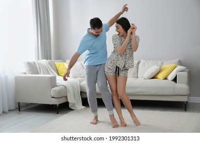 Happy Couple In Pajamas Dancing At Home