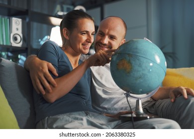 Happy Couple Picking A Destination On The Globe For Their Next Travel