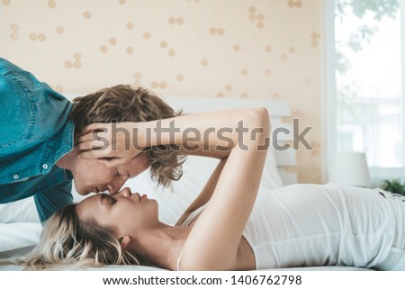 Similar – Beautiful woman looking to man lying on bed