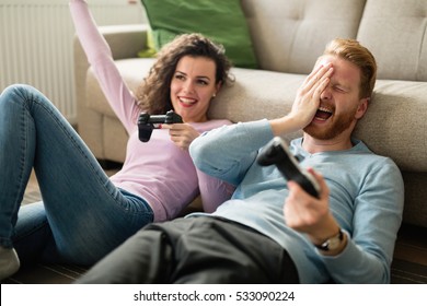 Happy Couple Playing Video Games  On Console And Having Fun