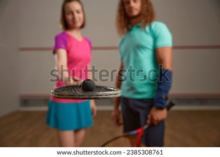 Happy couple posing for camera after squash game