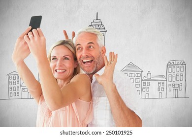 Happy couple posing for a selfie against white background - Powered by Shutterstock