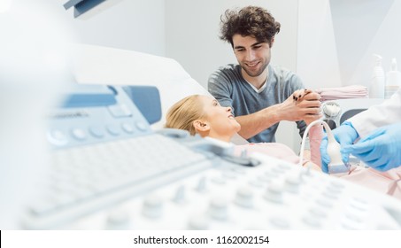 Happy Couple With Pregnant Wife At The Gynecologist In A Fertility Clinic