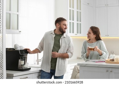 Happy couple preparing fresh aromatic coffee with modern machine in kitchen - Powered by Shutterstock