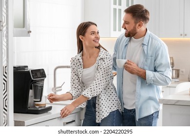 Happy couple preparing fresh aromatic coffee with modern machine in kitchen - Powered by Shutterstock