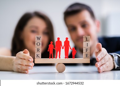 Happy Couple Protecting Balance Between Work And Life With Family Paper Cut Out On Seesaw